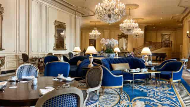 Elegant private dining room with plush blue seating for corporate meetings and social events.
