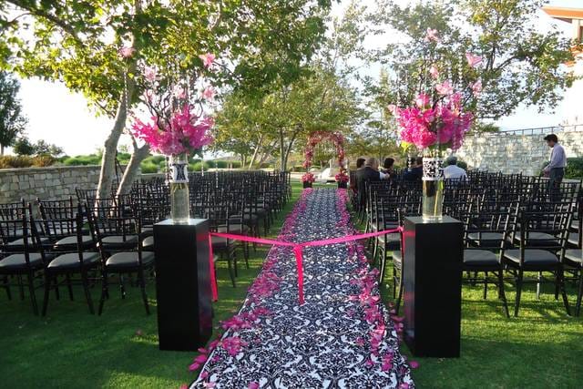 Elegant outdoor wedding ceremony at The Regency with black and white aisle runner.