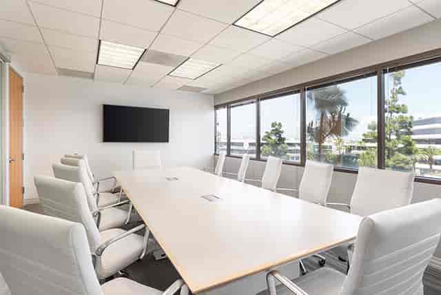 Modern conference room with large table, ideal for corporate meetings and presentations.