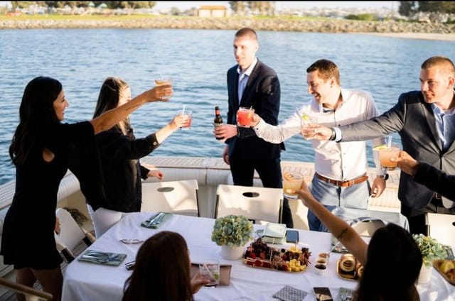 Vibrant outdoor networking event on a boat with elegant table setup and scenic waterfront.