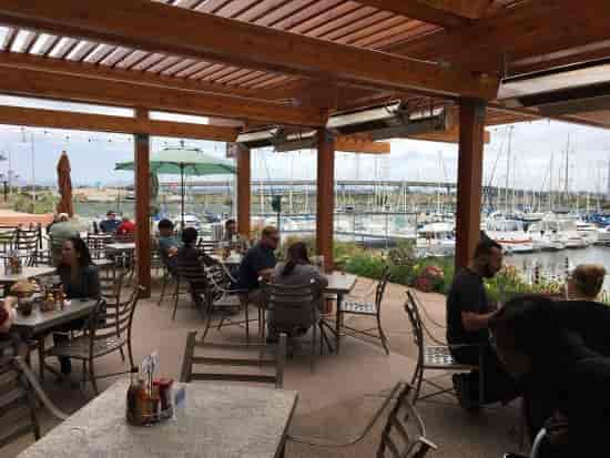 Vibrant waterfront bar with marina views, ideal for casual meetings and networking events.