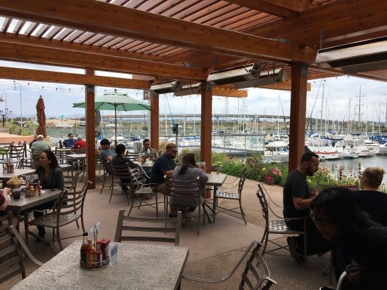 Vibrant waterfront bar with marina views, ideal for casual meetings and networking events.
