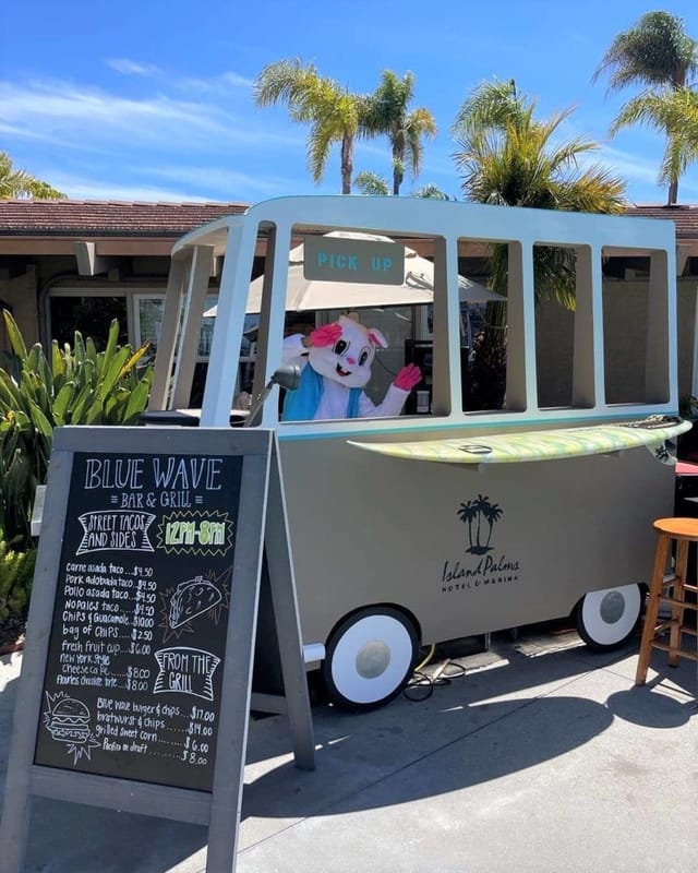 Blue Wave Bar & Grill food pickup station with playful mascot for family-friendly events.