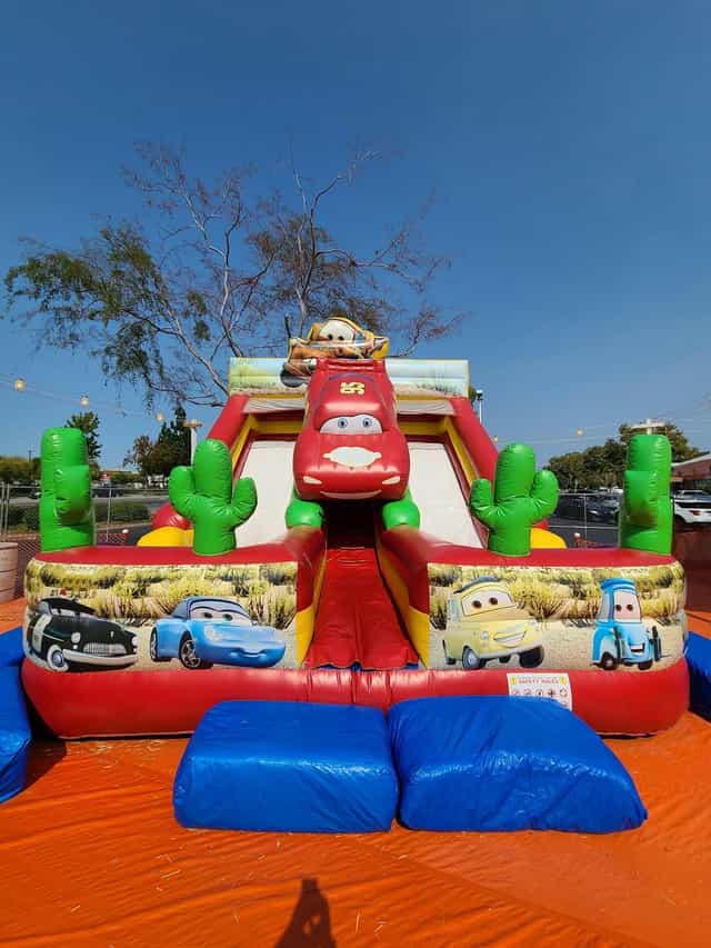 Glow in the Dark Room with vibrant Cars-themed inflatable slide for family events.