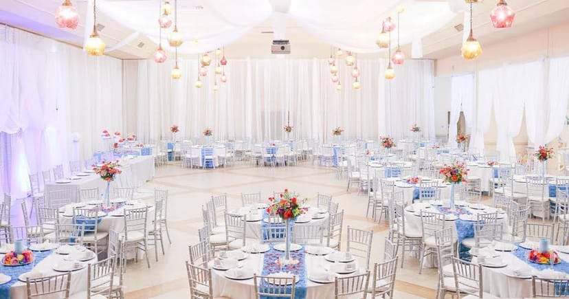 Elegant indoor wedding venue with round tables and floral centerpieces in Napredak Hall.