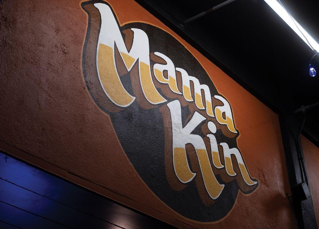 Vibrant Mama Kin venue with retro signage, ideal for casual meetings and networking events.