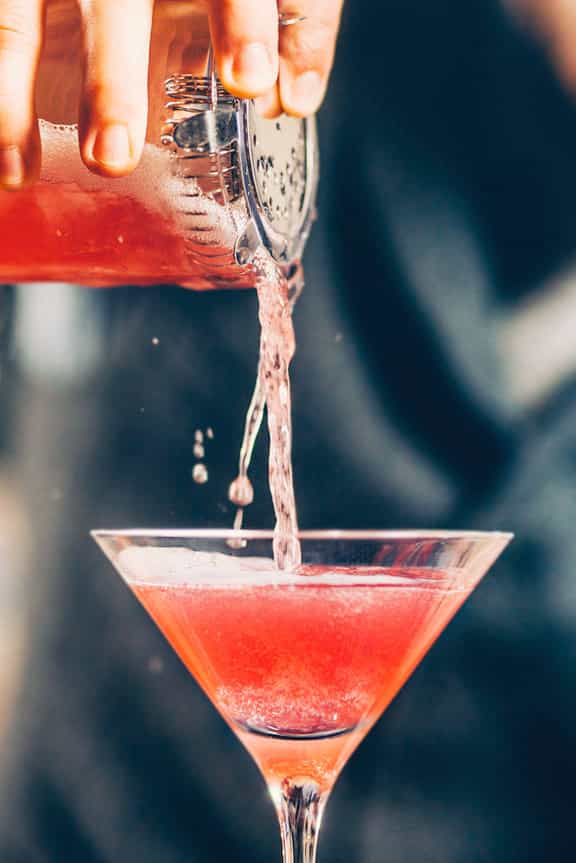 Vibrant cocktail in sleek martini glass at Mama Kin's sidewalk patio for upscale events.