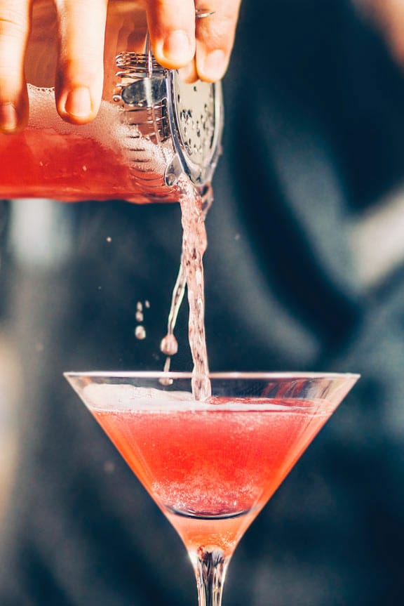 Vibrant cocktail in sleek martini glass at Mama Kin's sidewalk patio for upscale events.