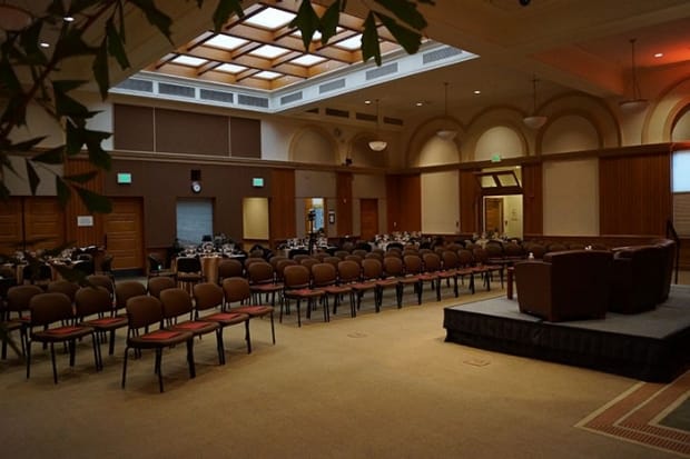 Encina Hall event space with chairs arranged for a presentation in warm lighting.
