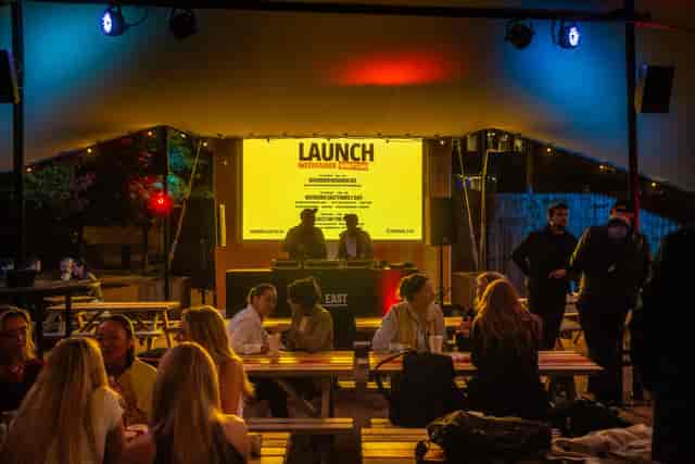 Vibrant outdoor product launch at The Yard, featuring colorful lighting and a stage.