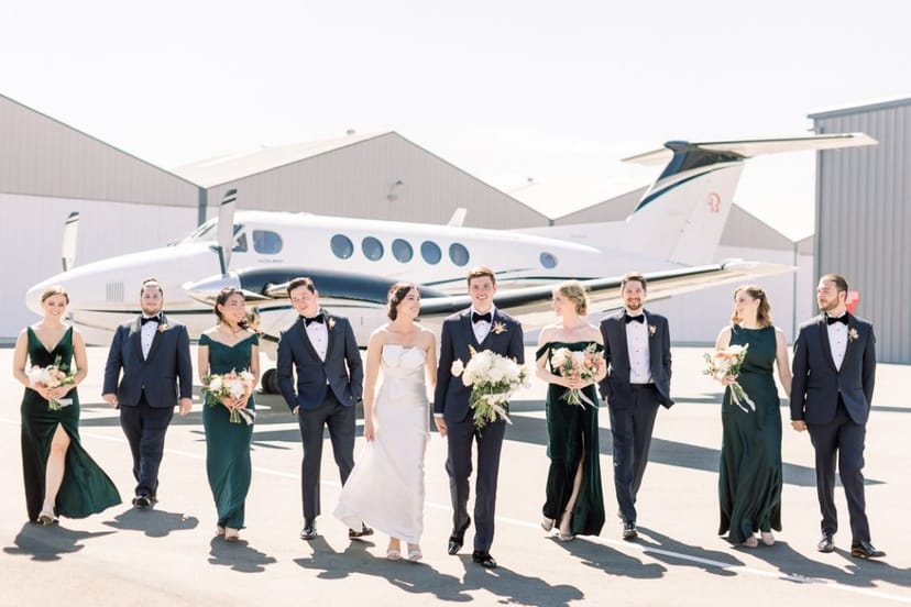 Stylish wedding party in formal attire by a private jet at Hangar 858.