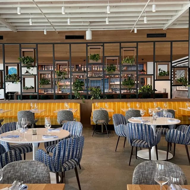 Modern dining space at ARLO San Diego, perfect for events with stylish seating and greenery.
