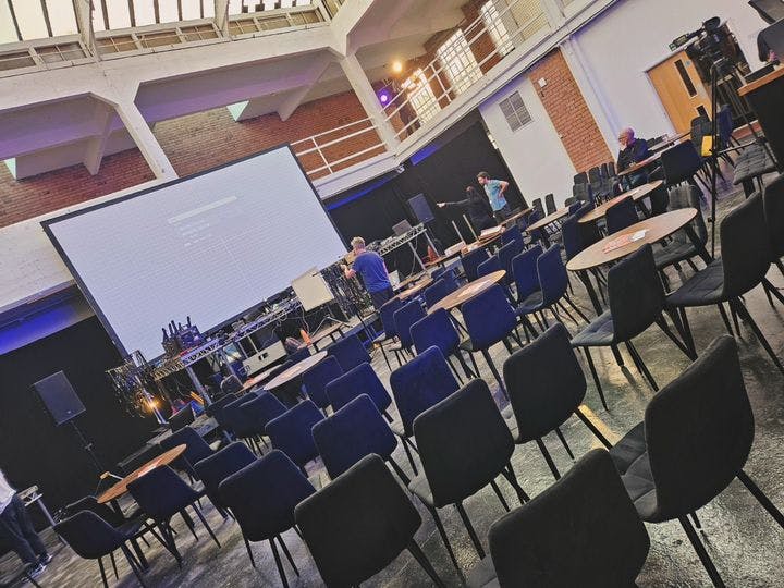 Birmingham Black Box Theatre meeting setup with chairs, tables, and presentation screen.