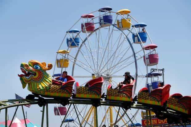 Colorful roller coaster and Ferris wheel at Santa Clara County Fairgrounds event venue.