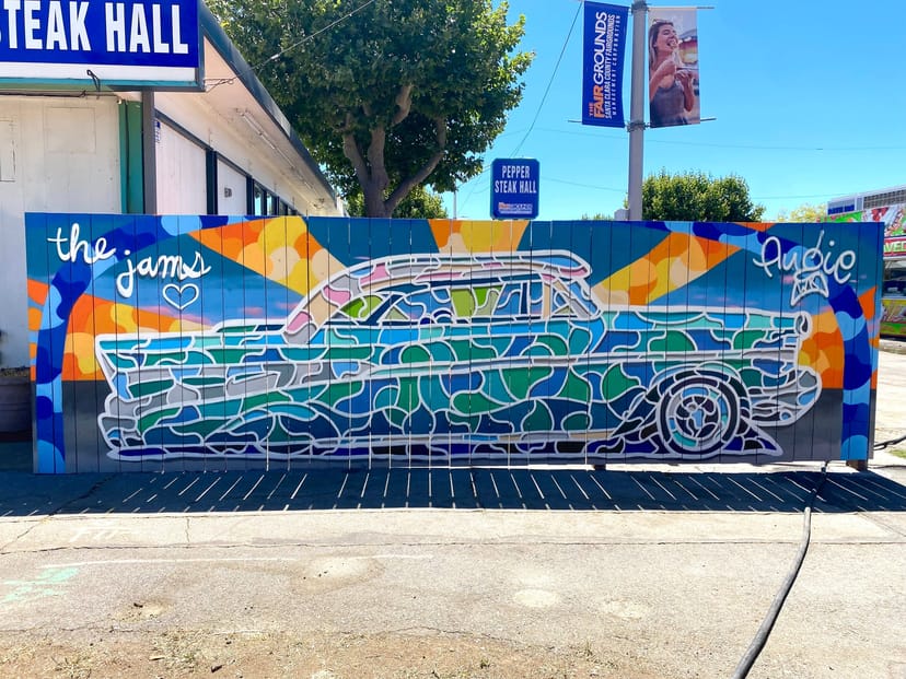 Vibrant mural of classic car at Pepper Steak Hall, perfect for outdoor events and festivals.