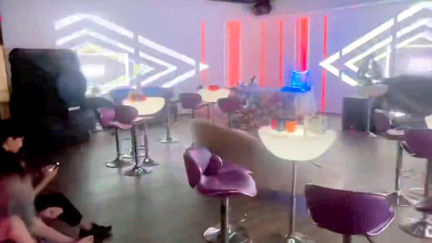 Private party room at Homestead Bowl with modern furniture and vibrant lighting.