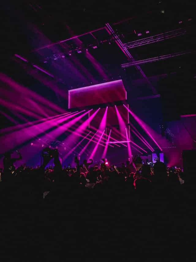 X-Bar Lounge event with vibrant purple lighting and engaged audience for concerts.