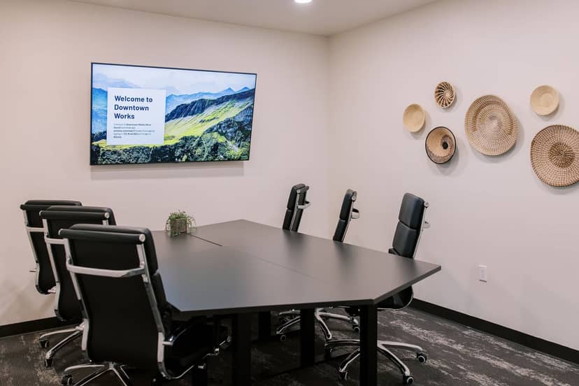 Modern conference room with black table, ideal for meetings and presentations.