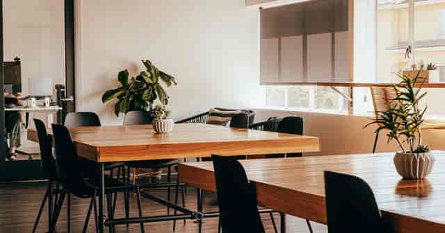 Modern coworking meeting space with wooden tables, ideal for workshops and brainstorming.