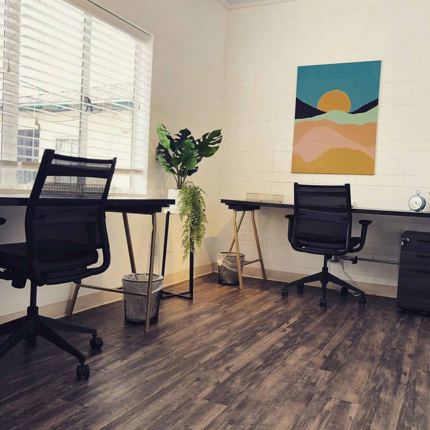 Modern minimalist coworking space with plants, ideal for meetings and collaboration.