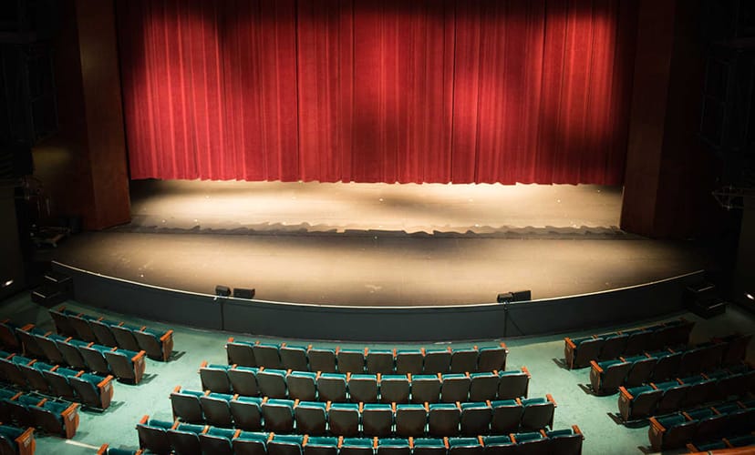 Parterre stage at Hammer Theatre with red curtains, perfect for conferences and performances.