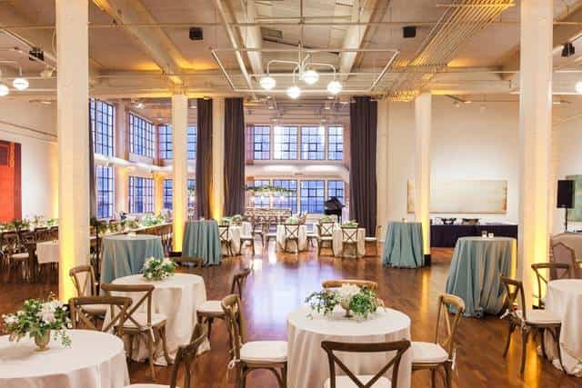 Elegant event space at TERRA Gallery with round tables and natural light for gatherings.