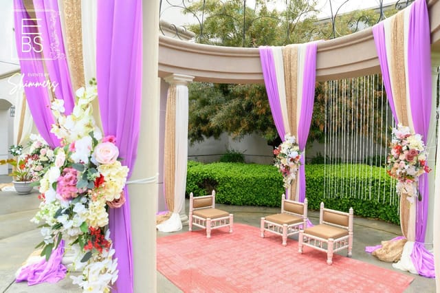Elegant outdoor event space with purple and gold drapery for intimate ceremonies.