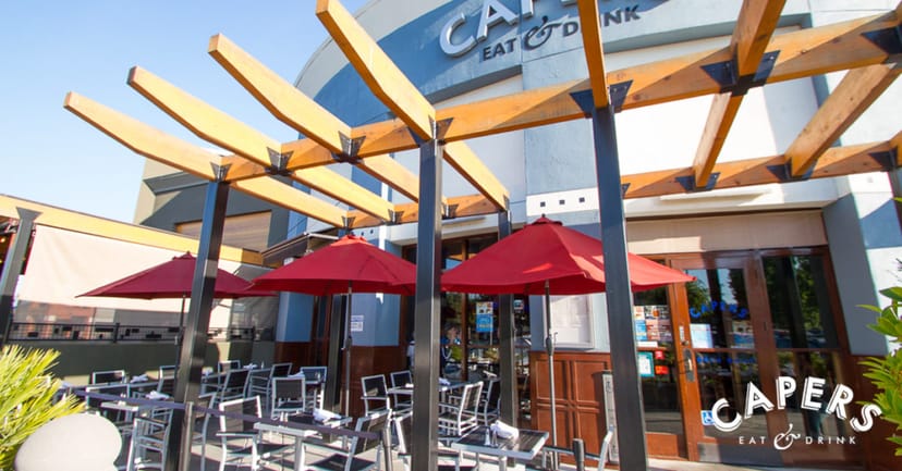 Vibrant outdoor dining patio with red umbrellas, perfect for casual networking events.