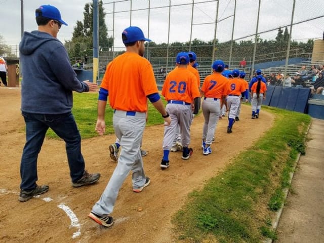 Youth baseball team in orange uniforms at PAL Stadium, San Jose - community sports event.