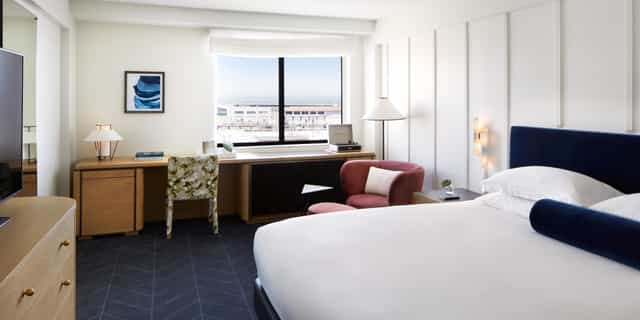 Modern hotel living room with workspace, ideal for business meetings and events.