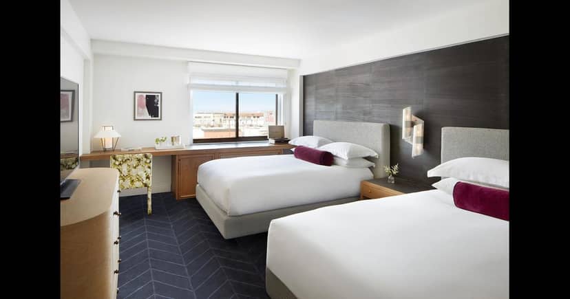 "Modern hotel living room with two beds, perfect for business and leisure events."