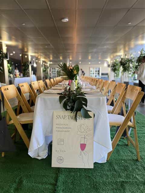 Elegant event space at Kimpton Alton Hotel with long dining table and floral decor.