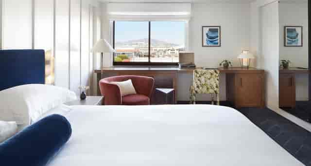 "Spacious hotel studio with cozy seating and workspace, ideal for business events."