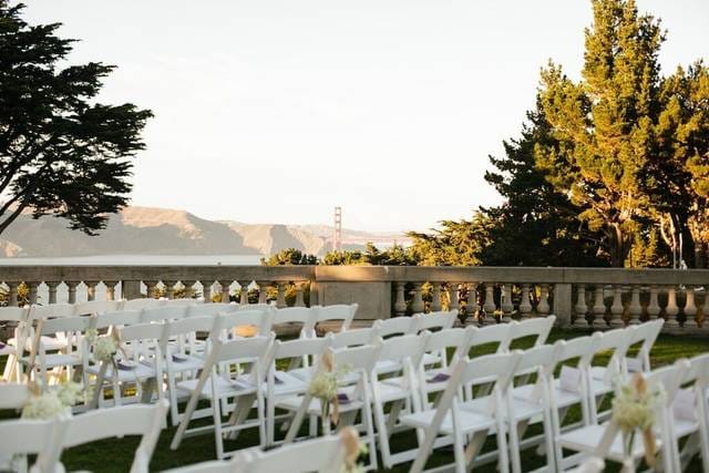Outdoor wedding venue with white chairs and scenic backdrop at Amazáe Events.