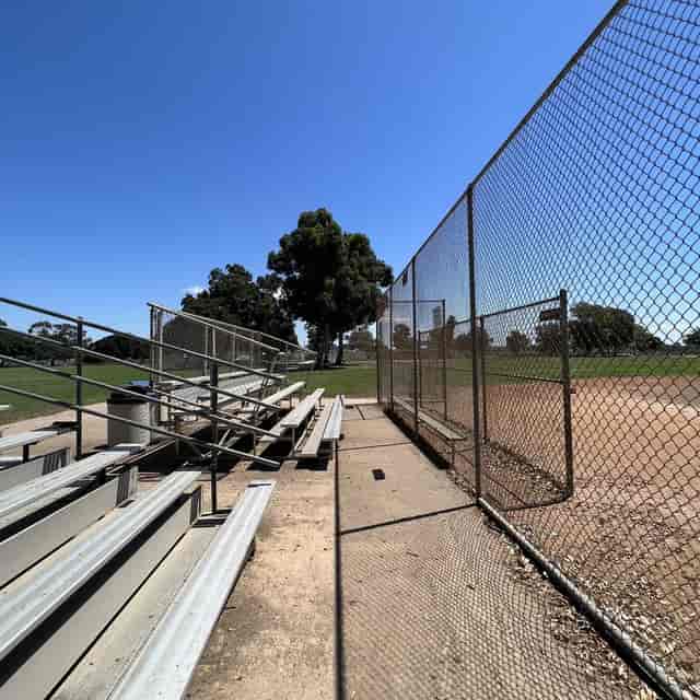 Softball field with bleachers at Park de la Cruz, perfect for community events and tournaments.