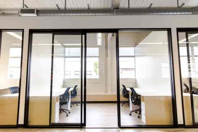 Modern private office space with glass walls, ideal for meetings and events.