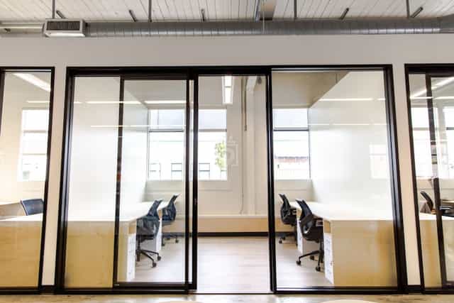 Modern private office space with glass walls, ideal for meetings and events.
