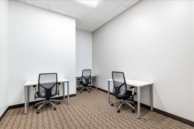 Minimalist coworking meeting space with desks for small group discussions in San Diego.