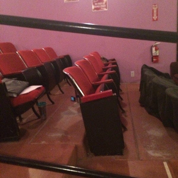 Cozy theater meeting space with vintage red chairs, perfect for intimate events.