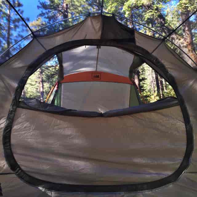 "RV campsite view from tent entrance, perfect for outdoor retreats and team-building events."