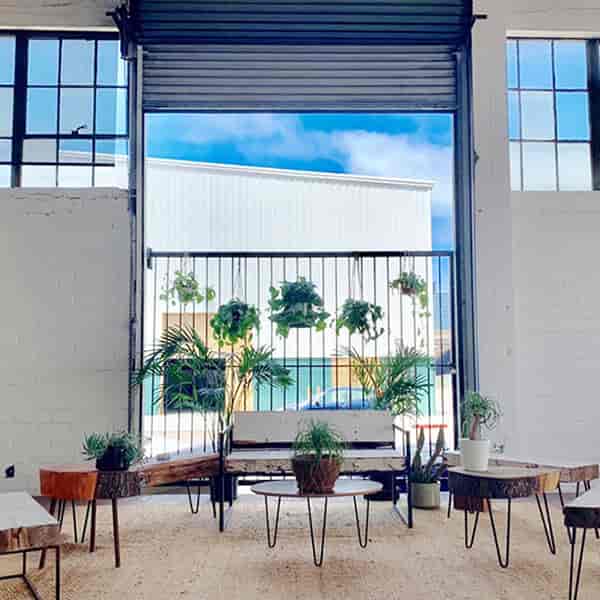 Stylish San Diego event space with large windows and rustic wooden tables for gatherings.