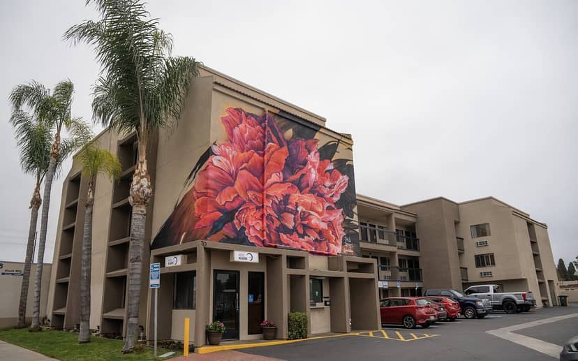 Modern Hotel Milagro guestroom with vibrant floral mural, ideal for events and meetings.