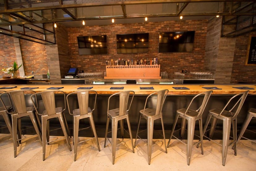Sleek modern bar with wooden counter, ideal for networking events and social gatherings.