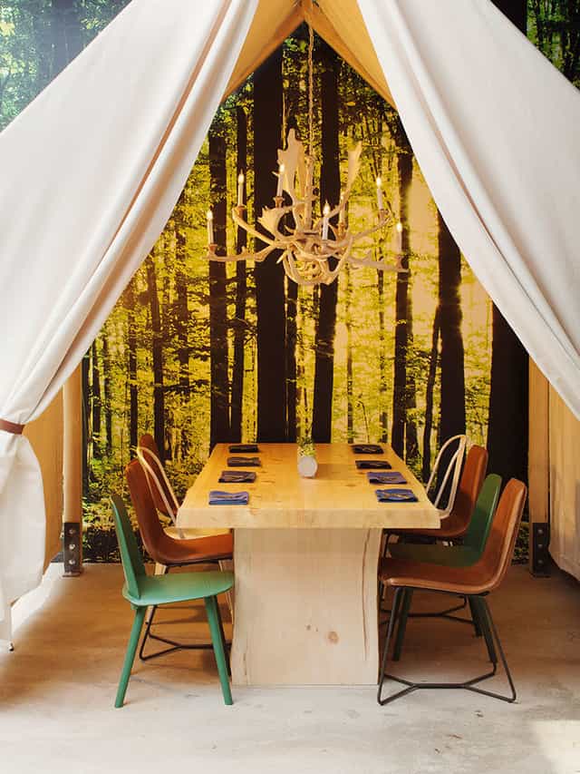 Private tents in One Door North with rustic table, ideal for creative meetings and gatherings.
