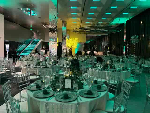 Elegant dinner setup in Morton's The Steakhouse, featuring fine china and teal lighting.