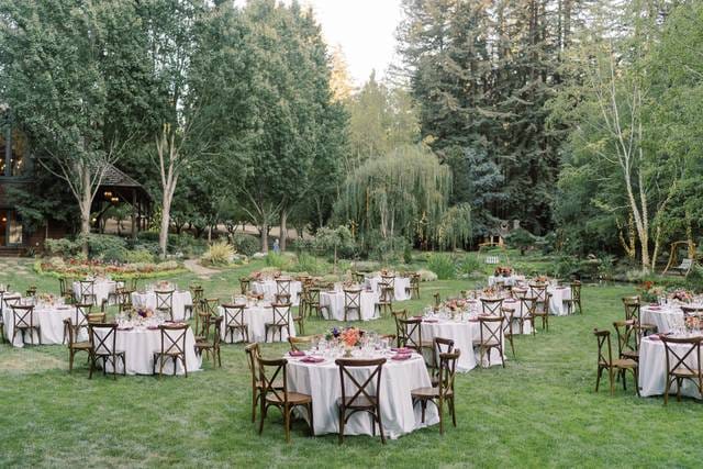 Alice in Wonderland table setup for a wedding in a lush outdoor venue.