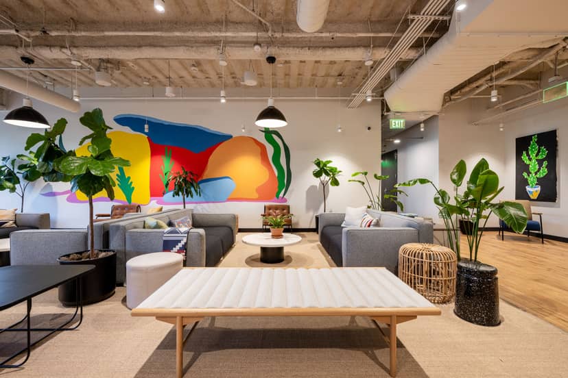 Modern lounge with colorful mural for networking events in San Carlos Street Executive Center.