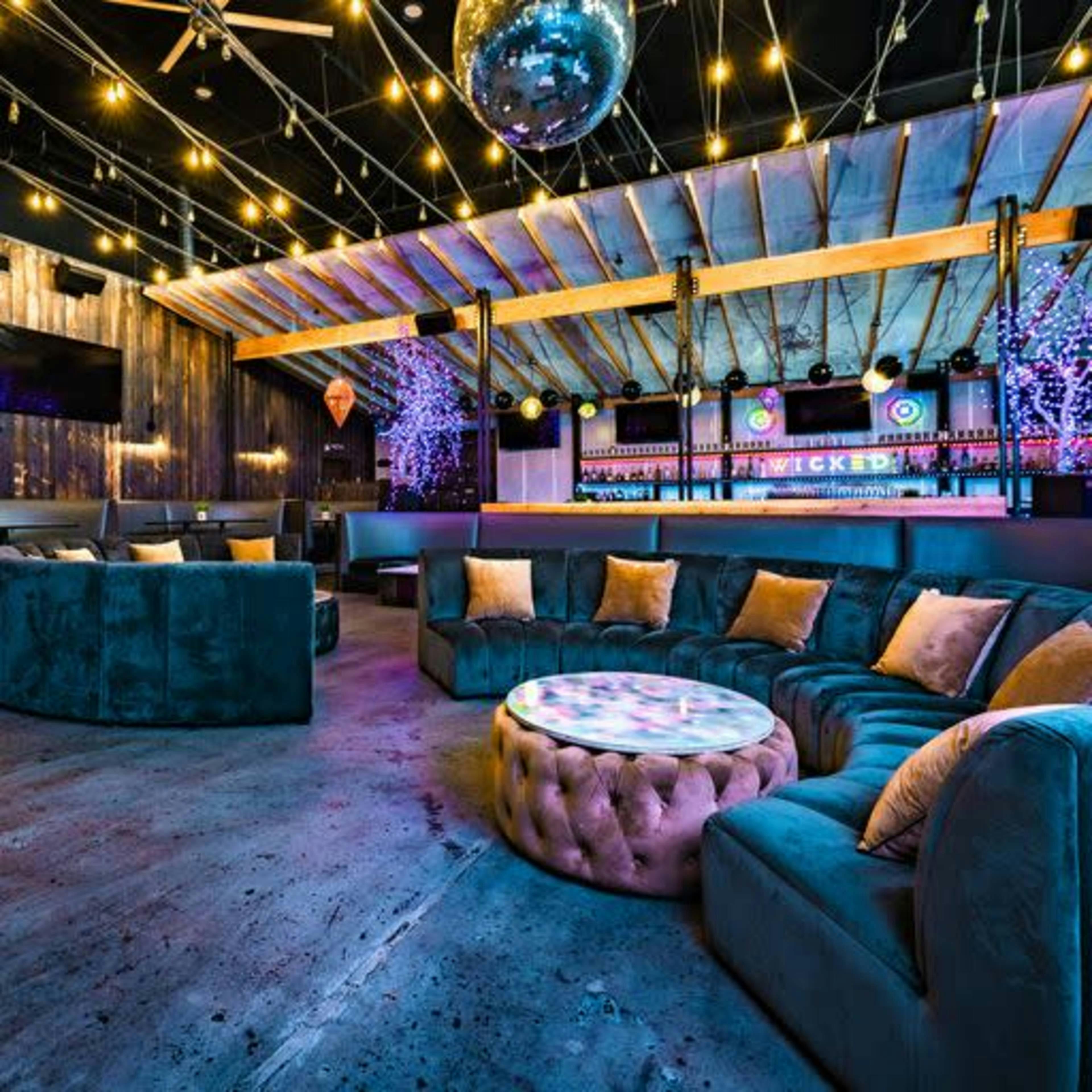Stylish event space with plush seating and vibrant bar for gatherings and corporate events.