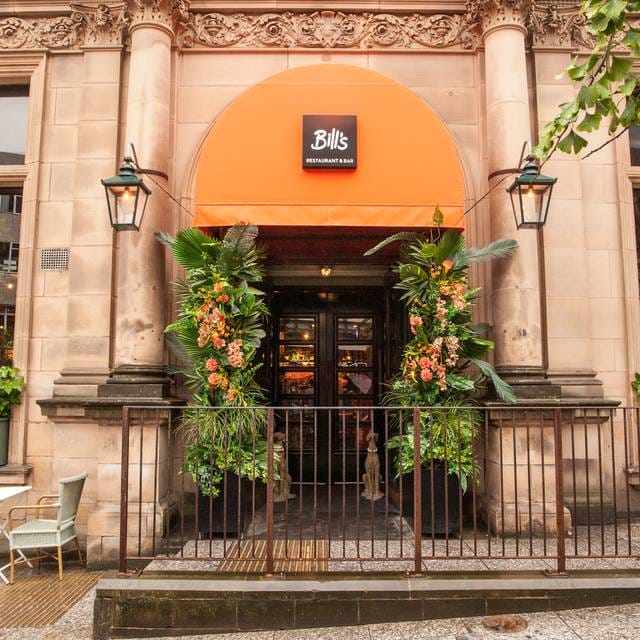 Vibrant restaurant entrance with greenery and orange awning, perfect for casual events.