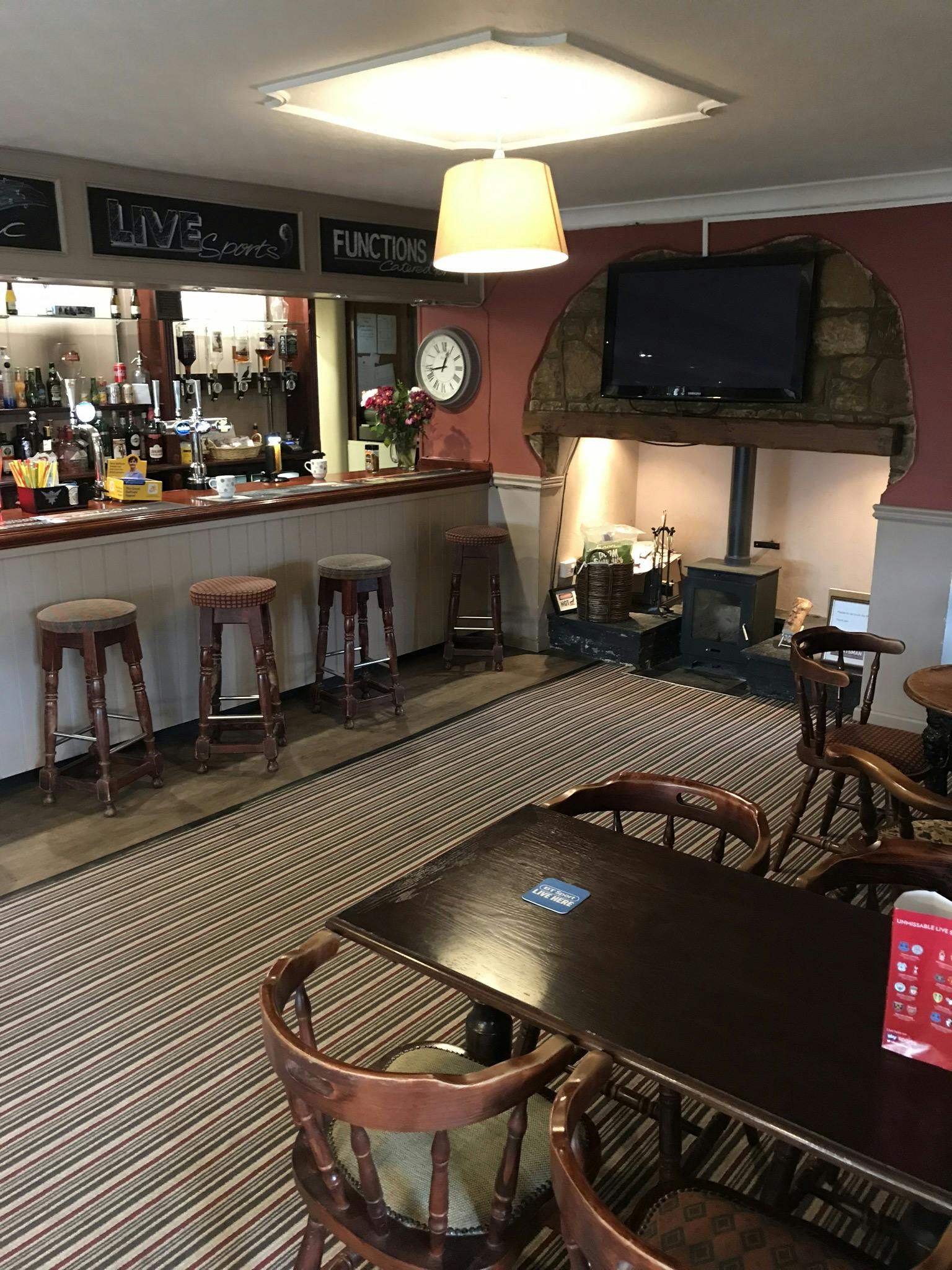 Cozy Sportsman Pub with inviting bar and fireplace, perfect for networking events.